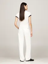 Remera blanca de algodón con cuello redondo y mangas cortas con ribete negro. Logo de Tommy Hilfiger bordado en el pecho.