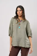 Blusa verde oliva de lino con cuello redondo, mangas cortas amplias con flecos, cierre lateral con botones y ruedo con flecos.