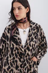 Tapado cruzado oversize confeccionado en paño con estampado de leopardo, con botones frontales y bolsillos aplicados.