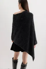 Poncho negro con detalles en gris, de tejido de punto grueso y corte asimétrico.
