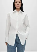 Camisa blanca de popelina de algodón y lyocell, con bordado floral en el frente, corte oversize, cuello camisero, mangas largas con puños abotonados y cierre frontal con botones.