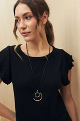 Top color rosado de tejido de punto acanalado, con cuello redondo y mangas cortas con volados.