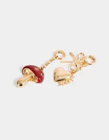 Set de dos charms dorados intercambiables para colgar en carteras o pulseras. Uno con forma de corazón con la palabra 'Love' y un moño, y otro con forma de hongo esmaltado en rojo con strass.