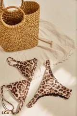 Conjunto de bikini blanco con textura, compuesto por un corpiño de triángulo fijo con breteles regulables y almohadillas desmontables, y una bombacha vedetina con frunce elástico en los costados.