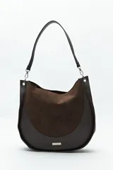 Bolso tipo hobo de cuero sintético negro con panel frontal de gamuza. Tiene correa de hombro ajustable y logo metálico plateado.