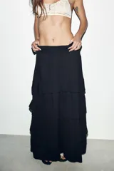 Falda larga negra de tiro alto con volantes en el mismo tejido.