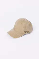 Gorra de gabardina color beige con visera curva y bordado frontal con la frase "the waves set the place" en marrón.
