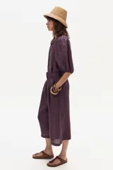 Bermuda color morado con diseño a cuadros, de tiro alto, corte amplio y largo a la rodilla.