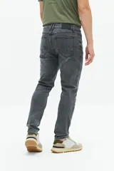 Jean slim azul oscuro, tiro medio, con pasacintos y confeccionado en 98% algodón y 2% spandex.