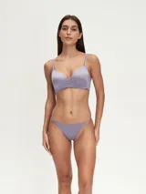 Conjunto de ropa interior color violeta, compuesto por un corpiño con breteles regulables y una tanga con laterales finos.