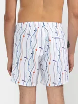 Short de baño blanco con estampado de cadenas, flores y libélulas en tonos azul, naranja y violeta.