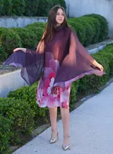 Vestido corto con cuello alto y mangas anchas, color morado con estampado floral en tonos rosados y blancos.