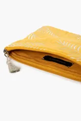 Sobre de terciopelo color amarillo con bordado de hojas de palmera en blanco y borla de hilo de lurex.