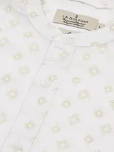 Camisa blanca con estampado de soles color beige, cuello mao, corte regular fit y mangas largas con presilla para remangar.