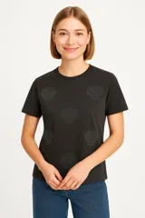 Remera negra de manga corta con cuello redondo y estampado de conchas marinas.