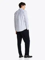 Camisa de popelín de puro algodón a rayas verticales blancas y celestes con logo de Tommy Hilfiger bordado en el pecho. Cuenta con cuello abotonado, mangas largas con puños abotonados y corte regular.