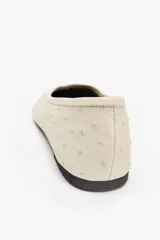 Zapato tipo bailarina color crema con relieve en el cuerpo, detalle de pespunte en el cerco y acabado en punta redonda.