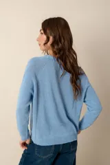 Cárdigan de punto color rosa claro, con escote en V y cierre frontal con botones nacarados.