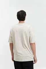 Remera de manga corta color marrón claro, de corte amplio y cuello redondo.