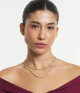 Collar dorado con tres cadenas de diferentes diseños: una de eslabones gruesos, una de eslabones pequeños y una de eslabones tipo serpiente.