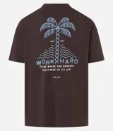 Remera marrón de corte relajado, confeccionada en algodón. Presenta cuello redondo, mangas cortas y estampa frontal y trasera de palmeras con la leyenda 'Work Hard'.