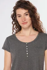 Remera color beige con escote redondo, manga corta, bolsillo en el pecho y cierre parcial con botones.