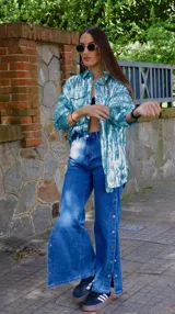 Chaqueta celeste con lentejuelas, corte tipo camisa, de manga larga y con bolsillos frontales.