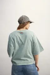 Remera color verde agua, de corte holgado y mangas cortas con dobladillo.