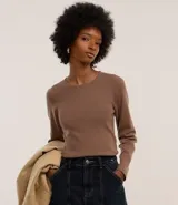Blusa color beige de jacquard con cuello redondo y mangas largas.