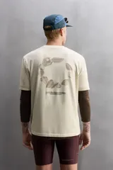 Camiseta color crema de corte holgado, cuello redondo y manga corta. Presenta un pequeño estampado con texto en el lado izquierdo del pecho.