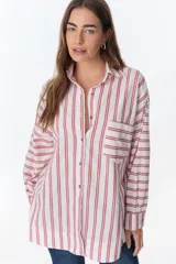 Camisa blanca con rayas verticales rojas, de corte holgado, manga larga y bolsillo en el pecho.