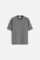 Camiseta gris de algodón, corte recto, cuello redondo y manga corta.