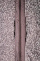 Cazadora marrón de tejido técnico ligero con partículas reflectantes. Tiene cuello alto con capucha elástica, mangas largas con puños elásticos, bolsillos frontales con cremallera en pecho y cadera, y cierre frontal con cremallera. Pertenece a la línea Zara Athleticz.