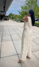 Pantalón cargo color blanco roto, de corte holgado, con bolsillos laterales y pliegues en la parte delantera.