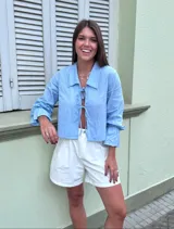 Short de gabardina color amarillo pálido, tiro alto, con pliegues frontales y bolsillos laterales.