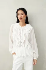 Camisa negra de tencel liviana con volados románticos y manga corta.