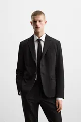 Blazer slim fit negra confeccionada en tejido con viscosa. Cuello con solapas de muesca, manga larga con puño con detalle de botones, bolsillo de vivo en pecho y de solapa en cadera, bolsillo interior, bajo con aberturas en espalda y cierre frontal con botones.