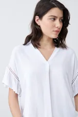 Blusa blanca con escote en V y mangas cortas con volados.