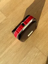 Neceser color beige de forma rectangular, con cierre superior y asa de mano.