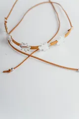 Gargantilla choker marrón de cuero sintético con apliques de estrellas blancas.