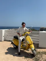 Remera color crema de corte recto y mangas cortas, con estampado en la espalda con el logo "ITTAI" en negro con líneas rojas, azules y blancas, y la leyenda "AN IBIZA PRODUCE. Ittai Stars Department Gallery - Ibiza Edition. If you're in Ibiza, 112 is not an option.".