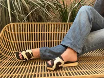 Zueco con capellada de cuero con estampado animal en blanco y negro, base de madera y suela de goma.