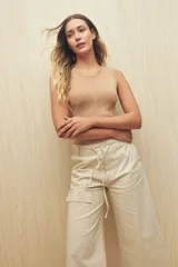 Pantalón capri color beige de algodón, con corte acampanado, bolsillos laterales tipo cargo y cintura con cordón ajustable.