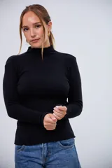 Polerita negra de manga larga, cuello alto y detalles ondulados en los puños y el dobladillo.