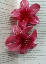 Pinza para el pelo color rosa con forma de flor.