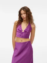 Top corto color violeta con cuello halter y detalle de aro metálico en el centro.