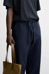 Pantalón azul marino de corte amplio, confeccionado en tejido de mezcla de algodón y lino. Cuenta con cintura elástica ajustable con cordón, bolsillos frontales y bolsillos traseros de vivo.