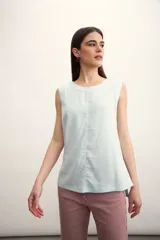 Blusa color crema sin mangas, de lino, con cuello redondo y corte recto.