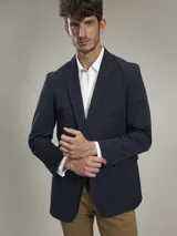 Blazer azul marino de corte clásico, con solapa de muesca, cierre de dos botones, bolsillo de parche en el pecho y bolsillos con solapa en los laterales.