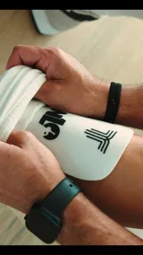 Espinilleras blancas con logo de la marca en negro.